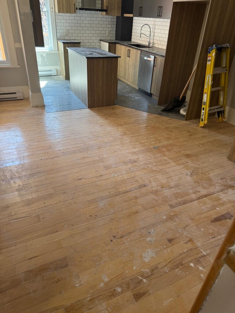 Plancher de bois franc poussiéreux et taché de peinture avant le nettoyage