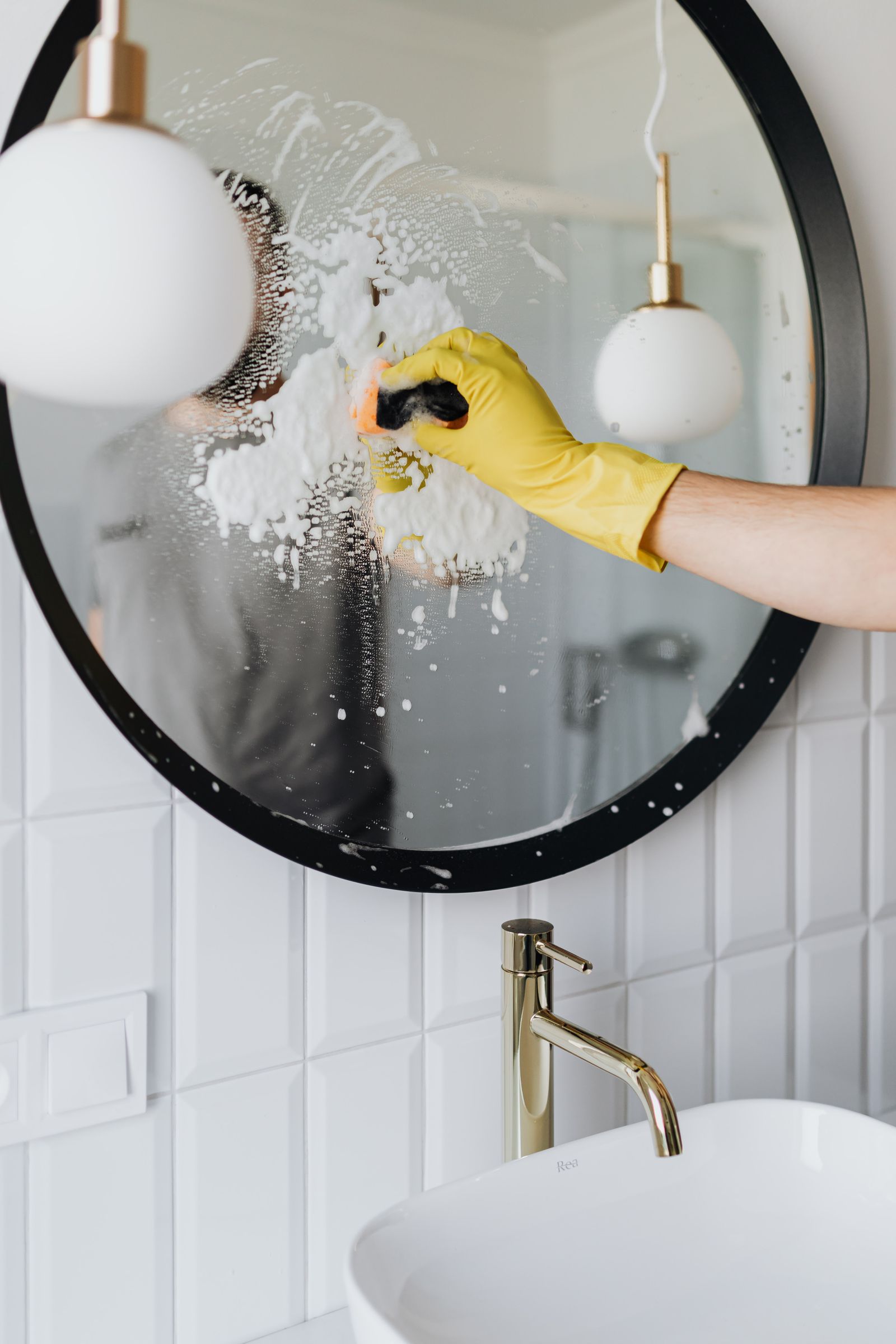 Cleaning a round mirror with a squeegee