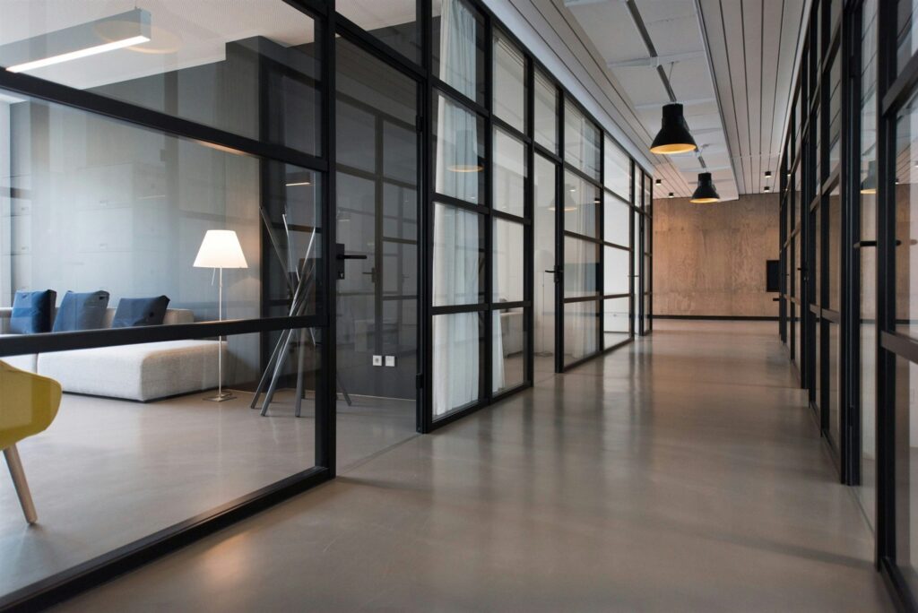 Couloir de bureaux aux cloisons vitrées et plancher poli