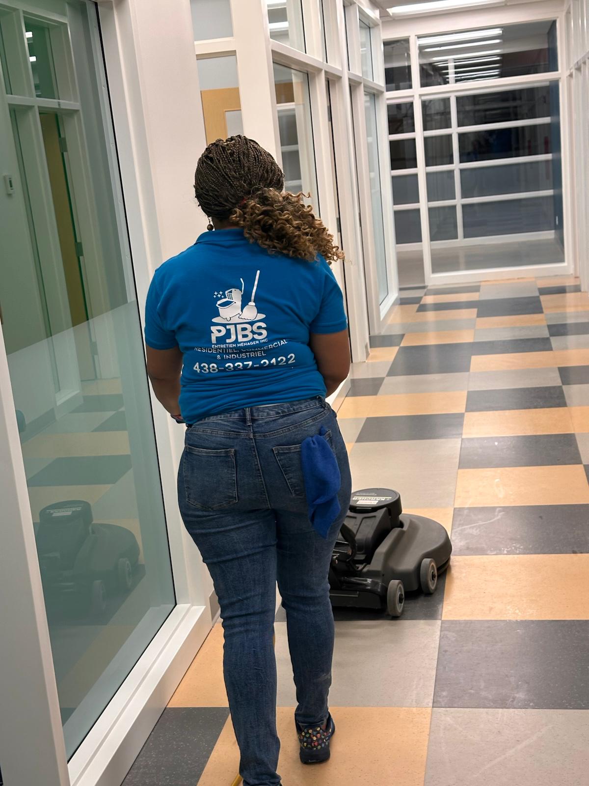Employée PJBS avec une autolaveuse dans un corridor